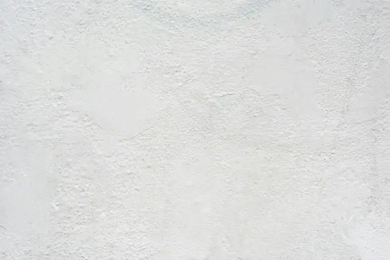 Gros plan d’un enduit blanc au grain irrégulier